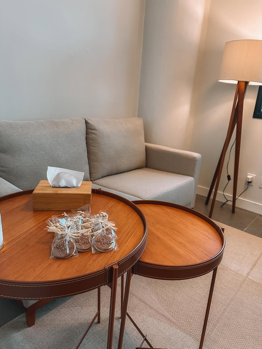 Sala de atendimento com poltrona clara, mesa redonda de madeira e caixa de lenços.